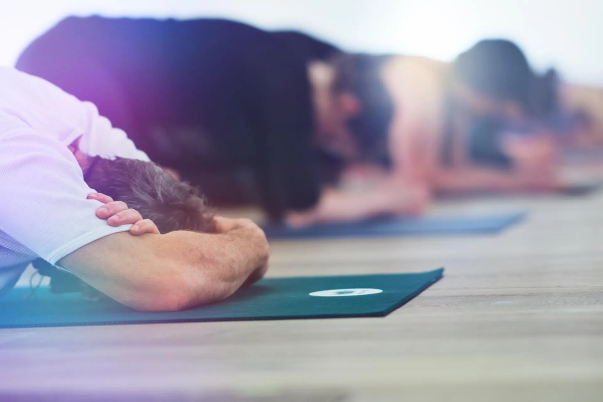 Gruppe in Kindshaltung, Bodenperspektive, Haende auf gruener Matte