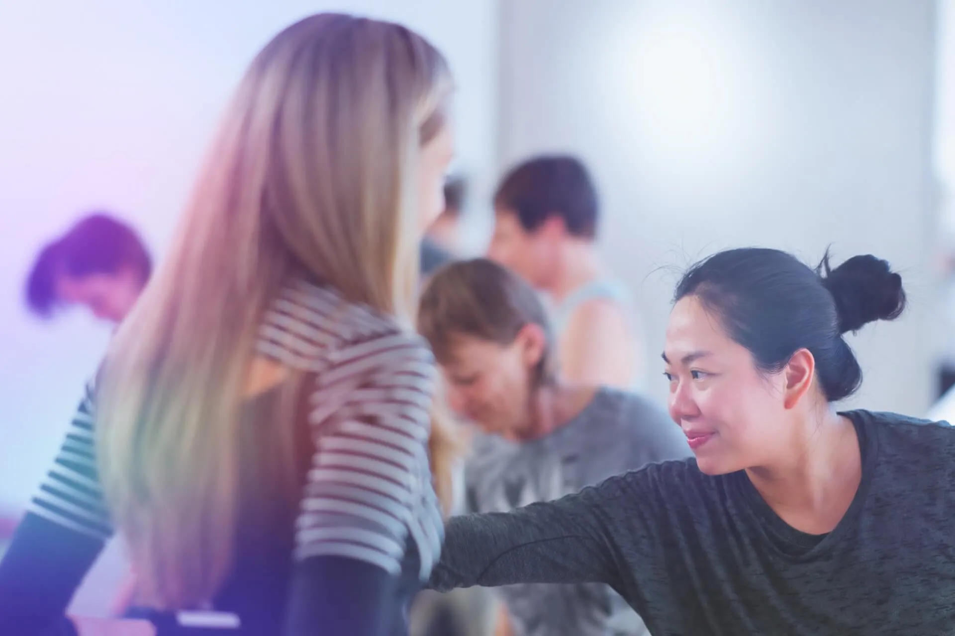 Zwei Frauen im Gespraech, blonde und asiatische Teilnehmerin