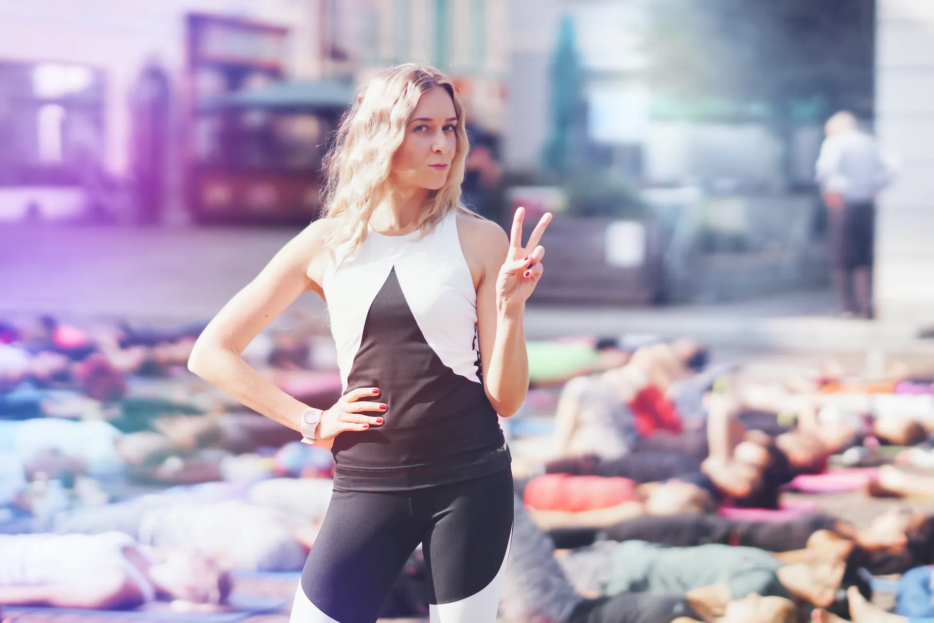 Suzanne zeigt Peace-Zeichen, Menge in Savasana dahinter